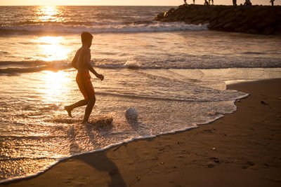 Silhouette woman walking at beach