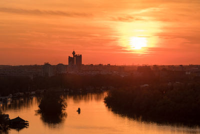 Reflection of buildings in city during sunset