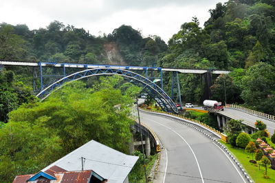 Bridge over road in city against sky