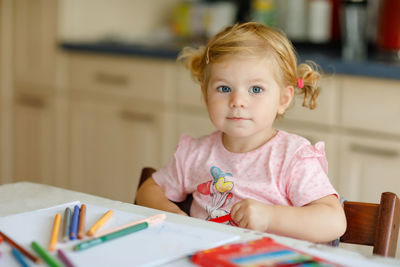 Portrait of cute girl sitting at home