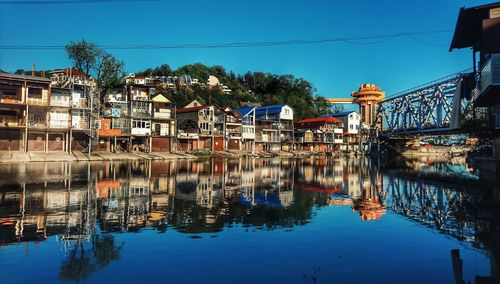 Reflection of built structure in water against clear sky