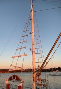 Sailboats moored in sea against clear sky