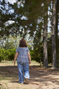 Rear view of woman walking in forest