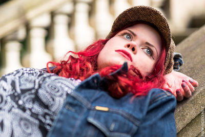 Close-up of thoughtful woman lying on railing