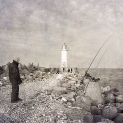 Lighthouse on rock against sky