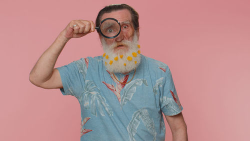 Portrait of man wearing hat against pink background