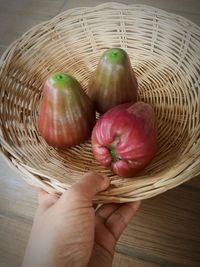 Close-up of hand holding strawberries in basket