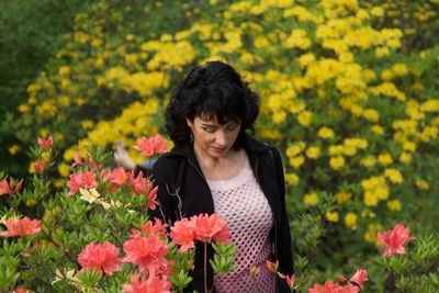 Woman standing by yellow flowers