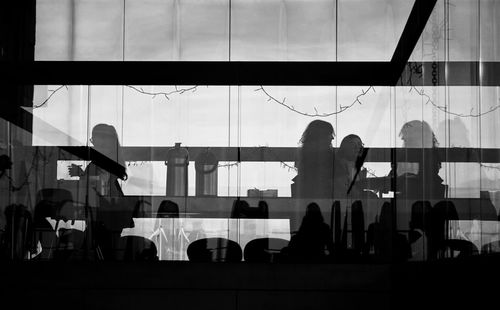 Silhouette of people in glass window