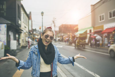 Portrait of woman with mouth open gesturing on road in city