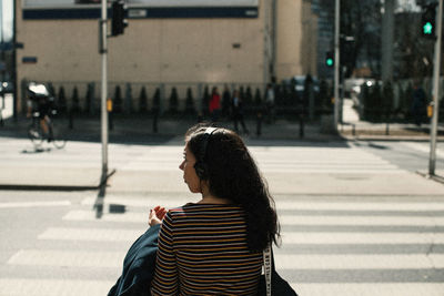 Side view of woman looking at city street