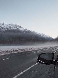 Car on road against snowcapped mountains