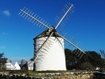 Low angle view of traditional windmill against clear blue sky
