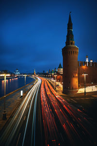 Light trails on street against buildings at night