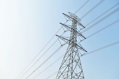 Low angle view of electricity pylon against clear sky