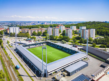 High angle view of football stadium and blocks of flats in background