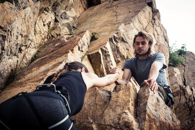 Full length of young man and rock on mountain