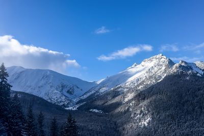 Scenic view of snowcapped mountains against blue sky