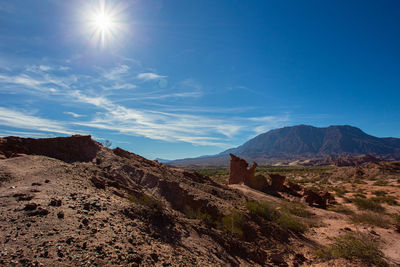 Scenic view of mountains against blue sky on sunny day