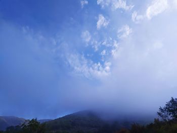Low angle view of mountain against blue sky