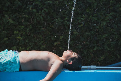 Low section of woman lying on swimming pool