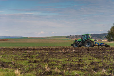 Tractor plowing fields at summer.