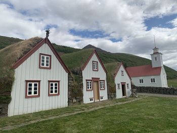 Exterior of houses by building against sky
