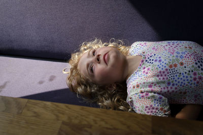 Portrait of girl lying down on seat 