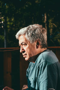 Profile view of thoughtful senior man sitting outdoors