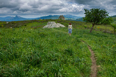 Woman standing on land against sky