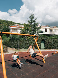 Rear view of woman sitting on swing at playground