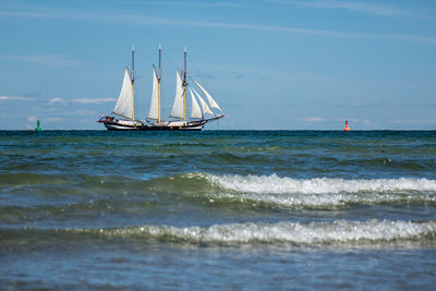 Sailboat sailing on sea against sky