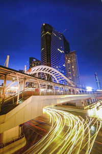 Light trails on building against sky at night