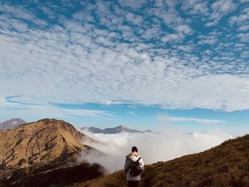 Man standing on mountain against sky