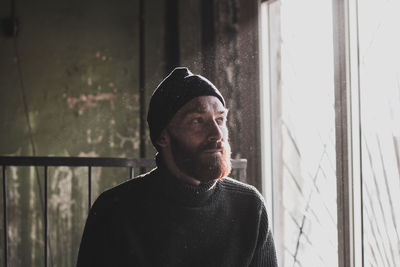 Portrait of man looking through window