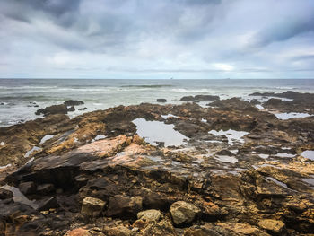 Rocks on beach against sky