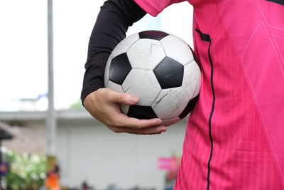 Midsection of woman playing soccer ball