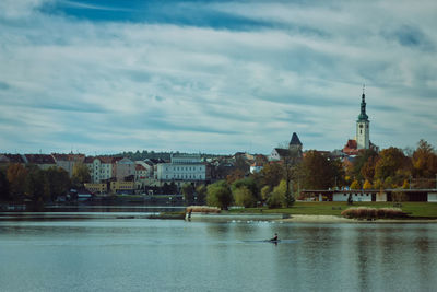 River by buildings in city against sky