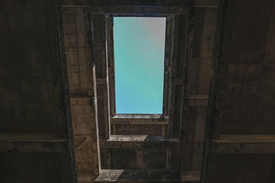 Old building against sky seen through window