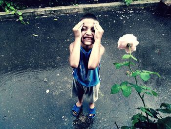 Portrait of happy boy with arms raised in water