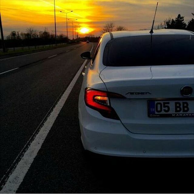 transportation, mode of transport, sunset, car, land vehicle, road, travel, sky, sun, on the move, orange color, vehicle interior, journey, street, no people, public transportation, road marking, cloud - sky, sunlight, windshield