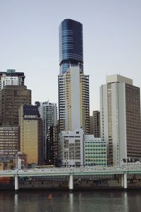 Modern buildings by river against sky