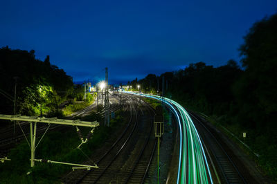 High angle view of light trails on railroad tracks against sky at night