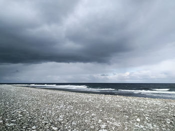 Scenic view of sea against storm clouds