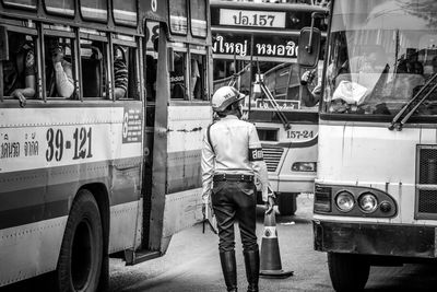 Traffic cop standing on street with buses in traffic jam
