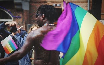 Side view of man standing at multi colored umbrella