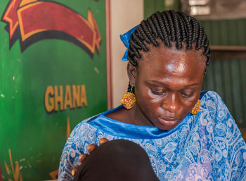 Africa ghana woman sitting inside a bar and having all the attention on her mobile phone