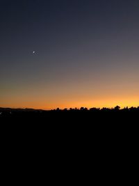 Silhouette landscape against clear sky during sunset