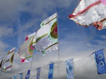 Low angle view of flags hanging against sky