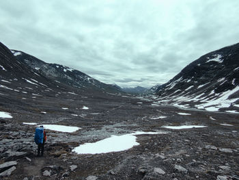 Rear view of person on snowcapped mountains against sky